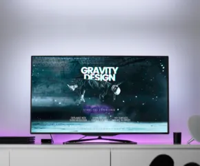 A modern living room featuring a large TV displaying the title screen of "Gravity Moon" with a dark, cosmic-themed background, acting as a template for home entertainment setups. - PSD Mockup