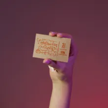 A person holding up a small brown paper mockup. - PSD Mockup