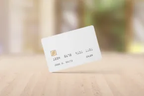 Credit card mockup on a wooden surface with a blurred background. - PSD Mockup