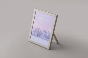 A digital photo frame displaying a serene purple-toned winter landscape mockup, placed on a light gray surface against a matching background. - PSD Mockup