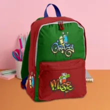 A colorful children's backpack with cartoon graphics mockup, placed on a table against a pink backdrop, accompanied by school supplies. - PSD Mockup