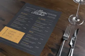 A restaurant table set with a menu, cutlery, and a wine glass serves as a template. - PSD Mockup