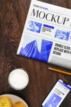 Newspaper template on a wooden table with a cup of coffee, cookies, and a smartphone. - PSD Mockup