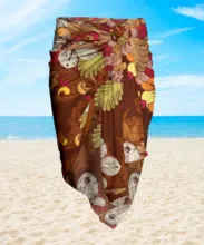 A colorful floral sarong fluttering in the breeze on a sandy beach with a clear blue sky in the background serves as a perfect mockup. - PSD Mockup