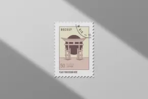 Postage stamp mockup featuring architectural design, placed on a surface with a soft shadow. - PSD Mockup