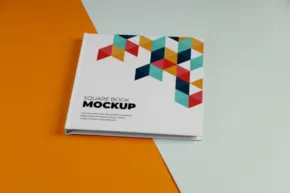 A book template lies on a dual-tone background with a geometric design on the cover. - PSD Mockup