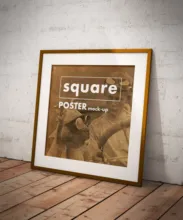 A framed poster titled "square mockup" leaning against a textured wall on a wooden floor. - PSD Mockup