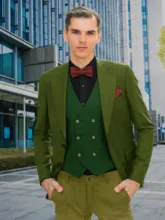 A man in a green blazer, vest, and bowtie standing in front of modern buildings serves as a perfect mockup. - PSD Mockup