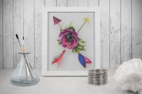 Framed abstract floral art with arrows, displayed on a wooden table, serving as a template for creative design. - PSD Mockup