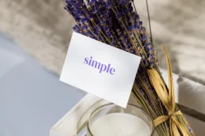 A bunch of dried lavender tied with a gold ribbon, beside a lit candle, with a card labeled "mockup. - PSD Mockup