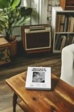 A template for a magazine displayed on a coffee table in a cozy room with vintage decor. - PSD Mockup