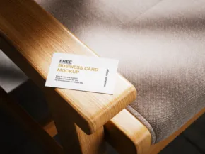 Business card mockup on a wooden bench with sunlight casting shadows on a gray cushion. - PSD Mockup