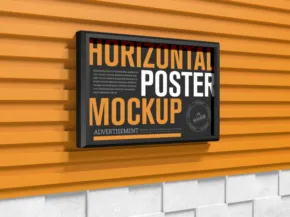Horizontal poster template on an orange brick wall, mounted in a black frame. - PSD Mockup