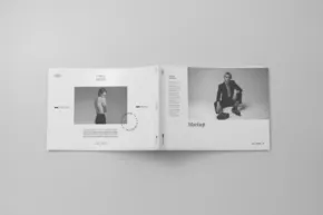 Open magazine template with monochrome photographs on a neutral background. - PSD Mockup