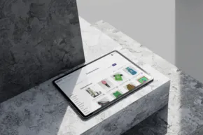A tablet featuring a mockup display of colorful app icons rests on a modern gray countertop. - PSD Mockup