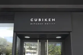 Storefront mockup of "cubiken outdoor design" with glass doors and modern facade. - PSD Mockup
