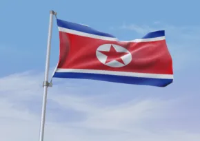 Flag of North Korea fluttering against a blue sky, serving as a template. - PSD Mockup