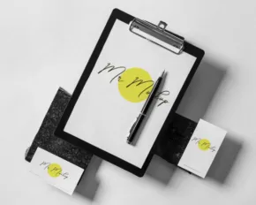 A mockup template of a clipboard with business cards and a yellow pen. - PSD Mockup