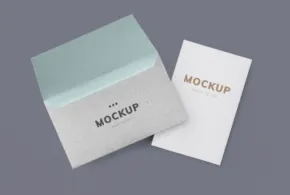 Two business cards template lying on a gray background, one stacked on top of the other partially visible. - PSD Mockup