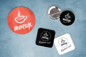 Four coffee-themed pins and stickers featuring the word "mocha" and a coffee cup logo, arranged on a blue textured mockup background. - PSD Mockup