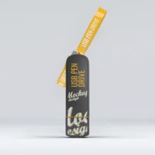 A black USB flash drive with a yellow strap, labeled with decorative gold text and branded as a mockup. - PSD Mockup