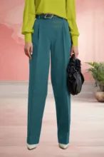 Woman in a green blouse and blue trousers holding a black bag, with the top half of her body cropped out of the frame, serving as a perfect template. - PSD Mockup