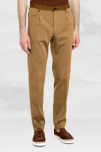 A mockup of a man from waist down wearing tan trousers, a brown belt, and dark brown shoes, standing against a light background. - PSD Mockup