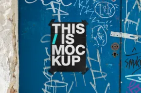 A worn blue door covered in scribbles and graffiti, featuring a black poster with "this is a mockup" in white text. - PSD Mockup