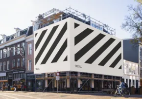 A modern building with bold black and white diagonal stripes on its facade, under construction, set against a clear sky in an urban area serves as a perfect template. - PSD Mockup