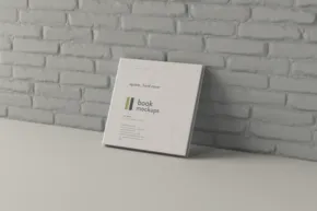 A white mockup binder labeled "seo strategy" with company logos leans against a gray brick wall on a white surface. - PSD Mockup