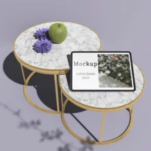Two marble-top tables with a digital tablet mockup, a green apple, and purple flowers. - PSD Mockup