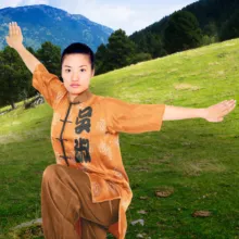 A woman in a tai chi outfit standing on a grassy field, serving as a template. - PSD Mockup