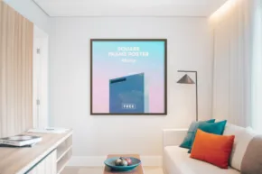 Modern living room with a large framed digital art mockup on the wall, a white sofa with bright pillows, and a minimalist coffee table. - PSD Mockup