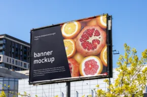 Outdoor billboard template displaying citrus fruits against a black background in an urban setting. - PSD Mockup