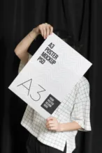 A woman holding up an a3 poster mockup template. - PSD Mockup