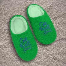 A pair of green slippers with "get well soon" embroidered on them, serving as a template. - PSD Mockup
