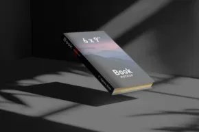 A closed book titled "siyah" resting on a surface, serves as a template, partly illuminated by sunlight casting diagonal shadows. - PSD Mockup