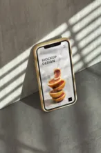 Smartphone mockup displaying a recipe on screen, cast in shadow and light. - PSD Mockup