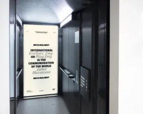 An empty modern elevator with an open door showing a mockup interior with a stainless steel finish. - PSD Mockup