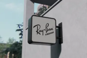 Ray-ban store mockup sign mounted on a building exterior. - PSD Mockup