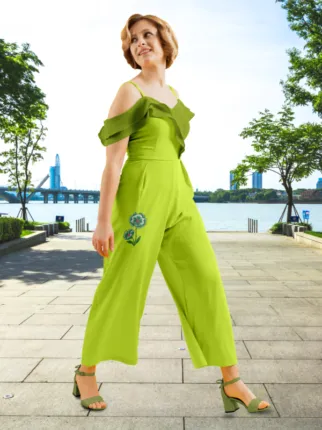 A woman in a bright green jumpsuit walks confidently on a city sidewalk with a bridge in the background, serving as a perfect mockup. - PSD Mockup