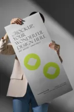 A woman holding up a poster template. - PSD Mockup