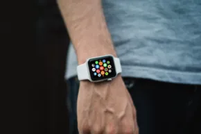A man is wearing a mockup of an apple watch on his wrist. - PSD Mockup
