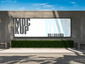 A billboard template in front of a building with palm trees. - PSD Mockup