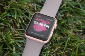 An apple watch mockup is laying in the grass. - PSD Mockup