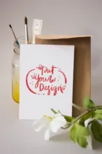A card with a flower on it next to a bottle of paint, perfect for creating a template. - PSD Mockup