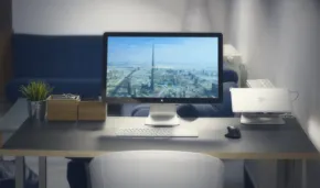 A mockup image of a desk with a computer and a view of a city. - PSD Mockup