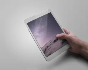 A mockup template of a hand holding up an iPad mini. - PSD Mockup