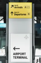 A sign at an airport terminal with arrows pointing in different directions, suitable for creating a mockup. - PSD Mockup