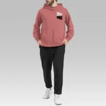 A man wearing a pink hoodie and black pants is posing for a mockup. - PSD Mockup
